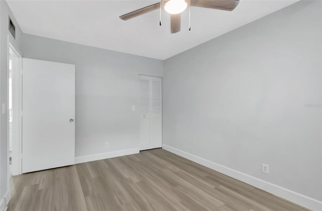 unfurnished bedroom featuring ceiling fan, light hardwood / wood-style floors, and a closet