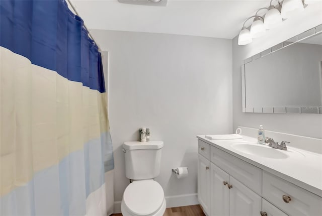 bathroom featuring vanity, toilet, curtained shower, and hardwood / wood-style floors