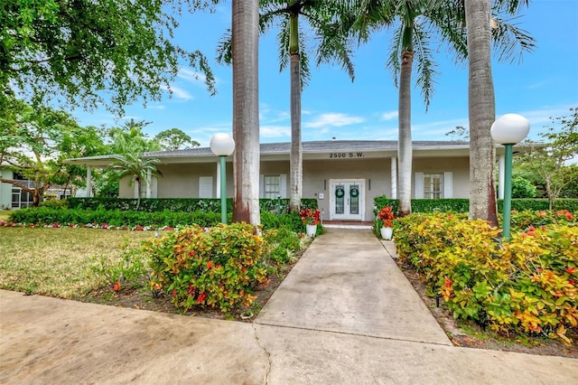 single story home with a front lawn and french doors