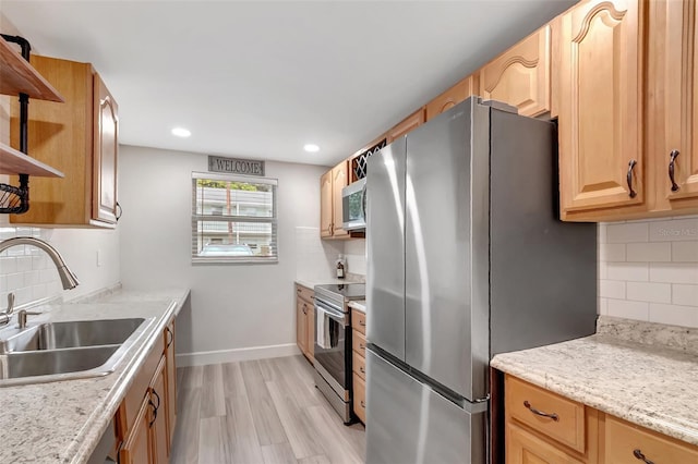 kitchen with stainless steel appliances, sink, decorative backsplash, and light hardwood / wood-style flooring