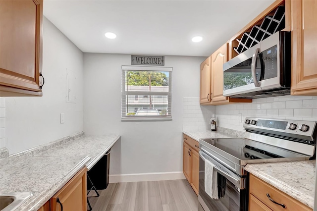 kitchen with stainless steel appliances, light stone countertops, and decorative backsplash