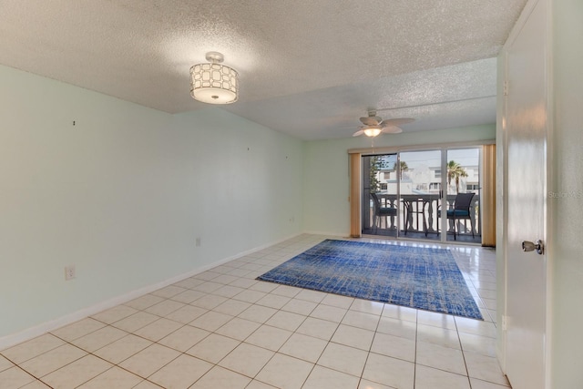 tiled empty room featuring ceiling fan and a textured ceiling