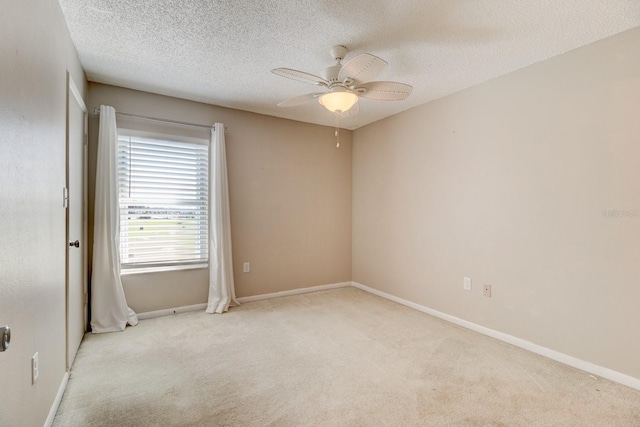 carpeted spare room featuring ceiling fan and a textured ceiling