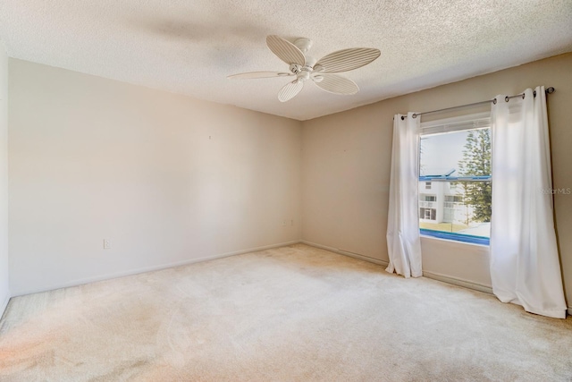 carpeted empty room featuring ceiling fan and a textured ceiling