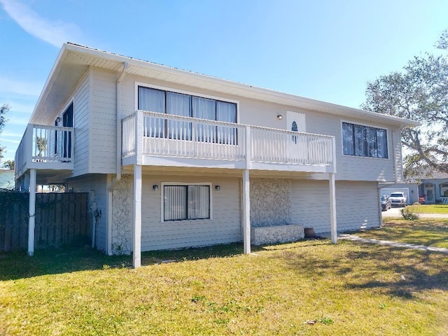 back of property with a balcony and a lawn