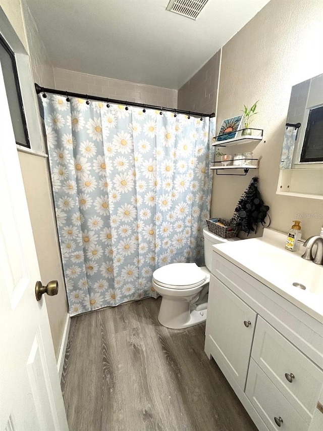 bathroom with vanity, hardwood / wood-style flooring, and toilet