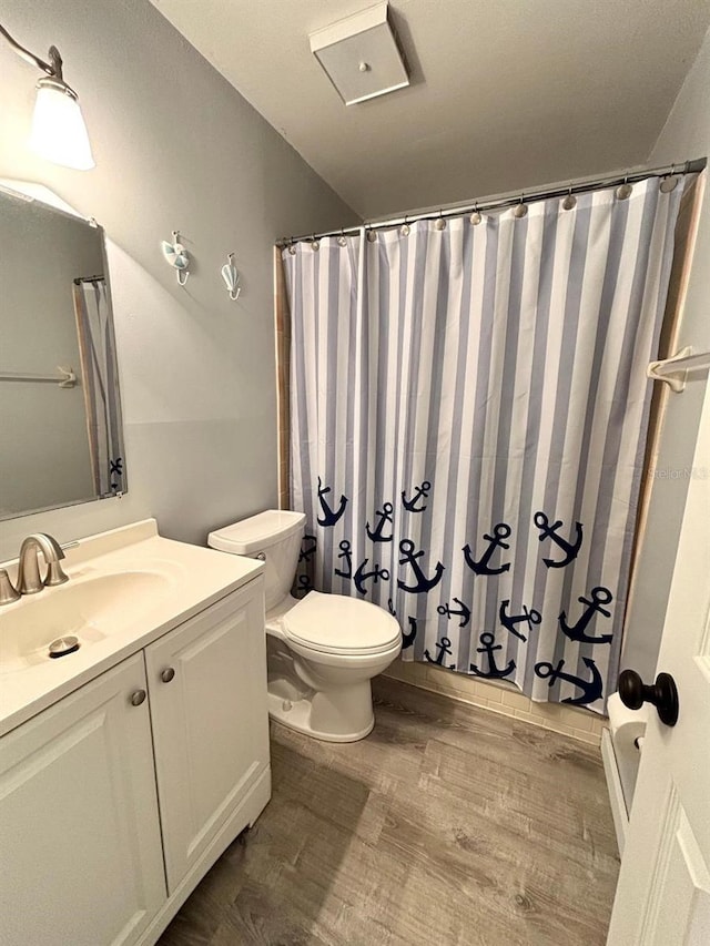 bathroom featuring wood-type flooring, toilet, curtained shower, and vanity