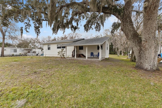 rear view of property featuring a patio area and a lawn