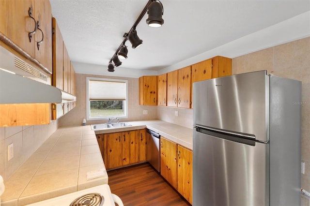 kitchen with stainless steel appliances, sink, tile counters, and backsplash