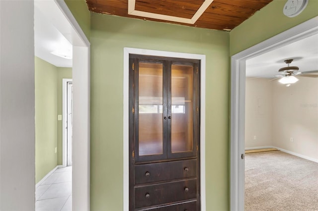 corridor featuring light tile patterned floors and wood ceiling