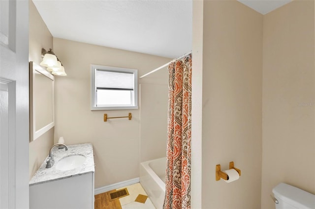 full bathroom featuring vanity, shower / bath combo with shower curtain, and toilet