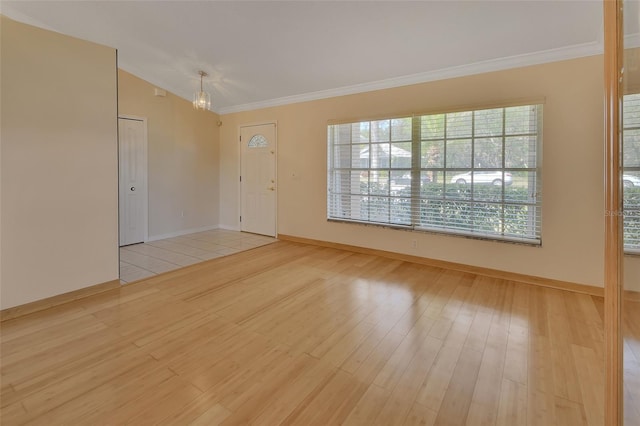 spare room with crown molding and light wood-type flooring