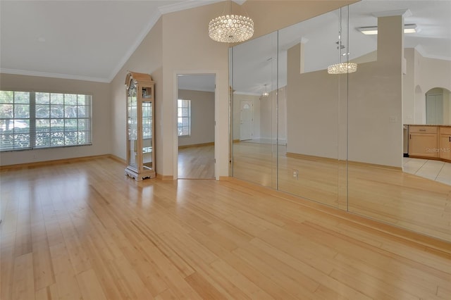 empty room featuring an inviting chandelier, a wealth of natural light, and high vaulted ceiling