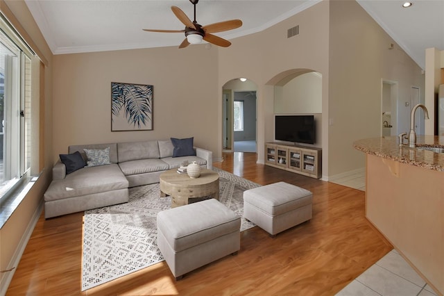 living room with ornamental molding, sink, ceiling fan, and light hardwood / wood-style floors