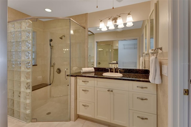 bathroom with walk in shower, vanity, and tile patterned flooring