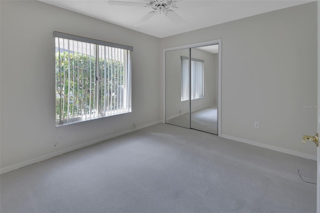 unfurnished bedroom with ceiling fan, carpet flooring, and a closet