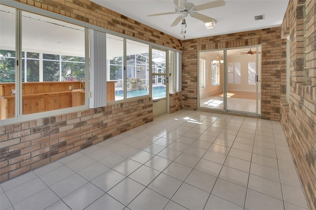 unfurnished sunroom with ceiling fan