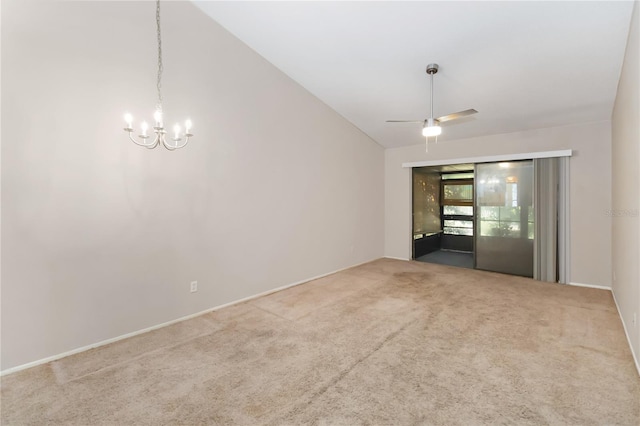 spare room featuring carpet, ceiling fan with notable chandelier, and lofted ceiling