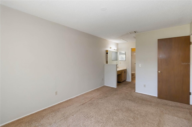 unfurnished bedroom with ensuite bath and light carpet