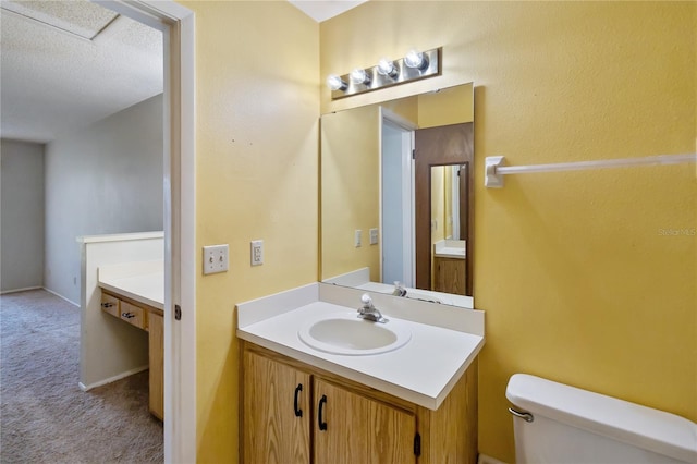 bathroom featuring vanity, a textured ceiling, and toilet