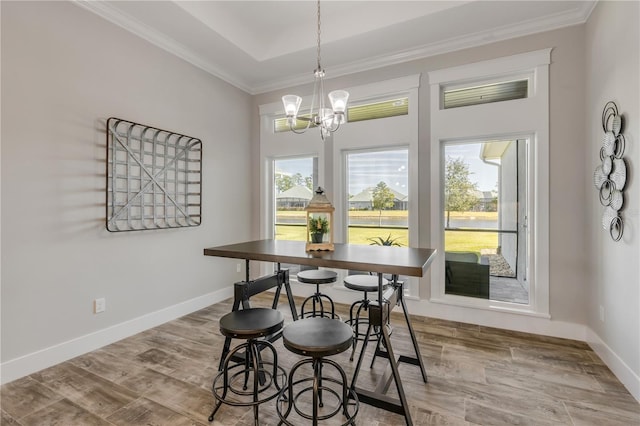 dining space with crown molding, wood-type flooring, and a chandelier