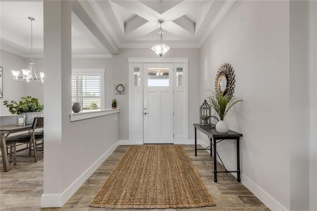 foyer featuring crown molding, an inviting chandelier, beam ceiling, coffered ceiling, and light wood-type flooring