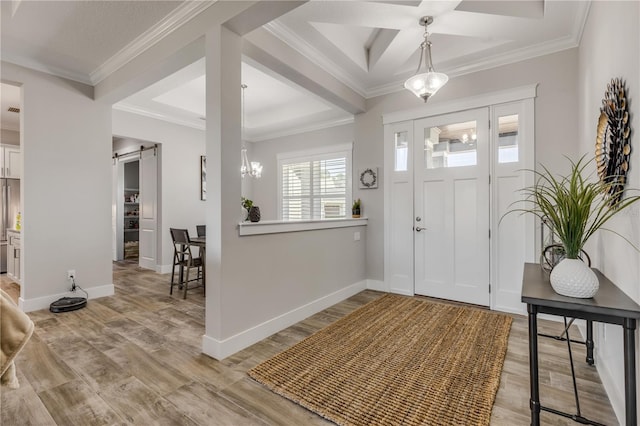 foyer entrance with coffered ceiling, ornamental molding, a barn door, and light hardwood / wood-style flooring