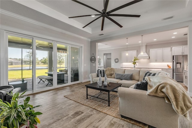 living room with crown molding, ceiling fan, and light hardwood / wood-style flooring