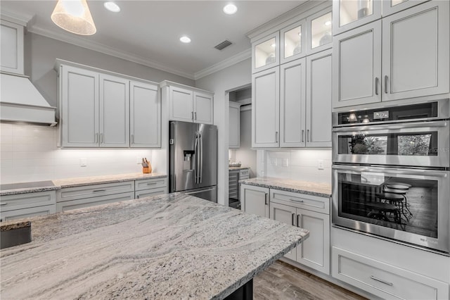 kitchen with white cabinetry, decorative light fixtures, tasteful backsplash, and stainless steel appliances