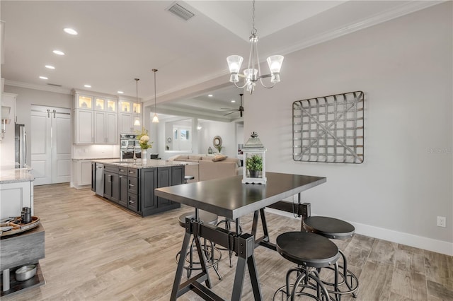 dining space with ceiling fan with notable chandelier, ornamental molding, sink, and light wood-type flooring