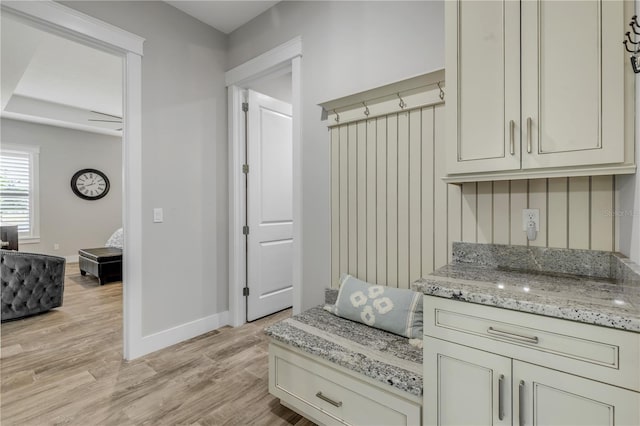 kitchen featuring light stone countertops, cream cabinets, and light hardwood / wood-style flooring