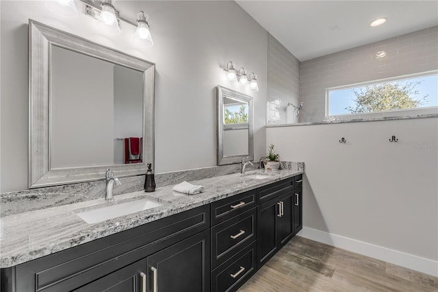 bathroom featuring hardwood / wood-style flooring, vanity, and a shower