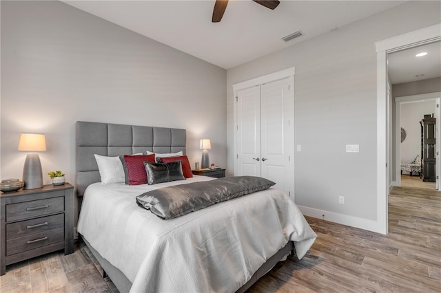 bedroom featuring light hardwood / wood-style flooring, ceiling fan, and a closet