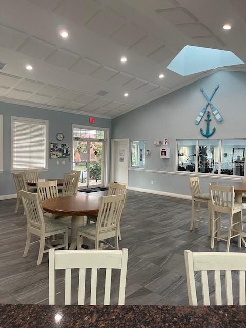 dining space featuring a skylight and high vaulted ceiling