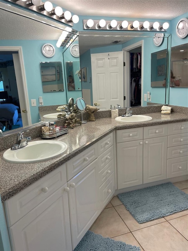 bathroom featuring vanity, tile patterned floors, and a textured ceiling