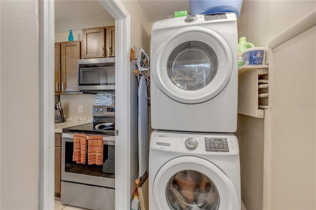 laundry area with a textured ceiling and stacked washer / dryer