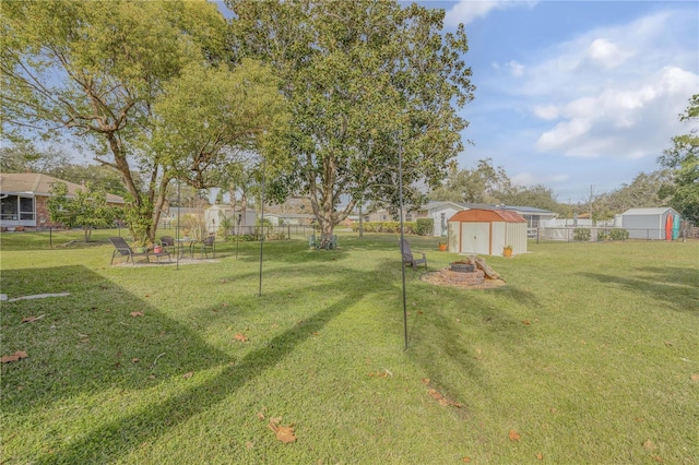 view of yard with a storage unit and an outdoor fire pit