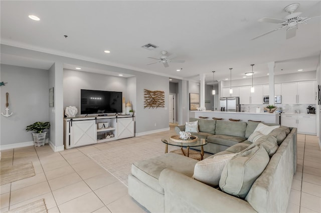 living room with ceiling fan, ornamental molding, and light tile patterned floors