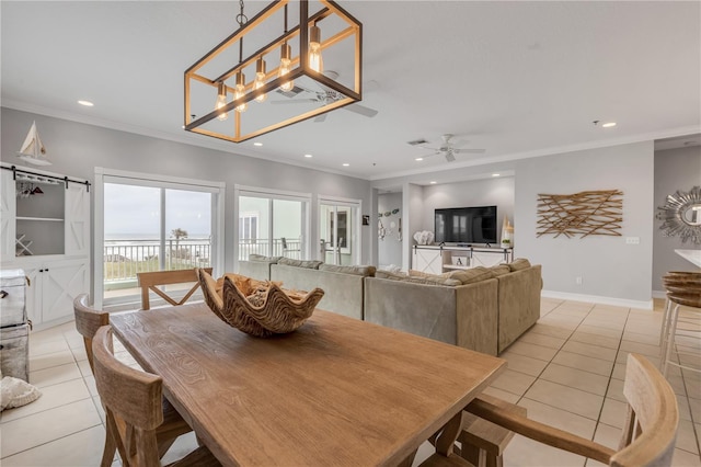 dining space with ornamental molding, a barn door, and light tile patterned floors