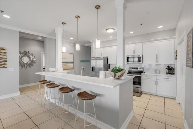 kitchen with stainless steel appliances, white cabinetry, hanging light fixtures, and a center island