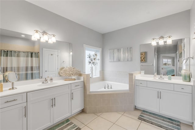 bathroom with tile patterned flooring, vanity, and a relaxing tiled tub