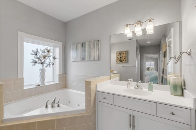 bathroom featuring vanity and tiled tub