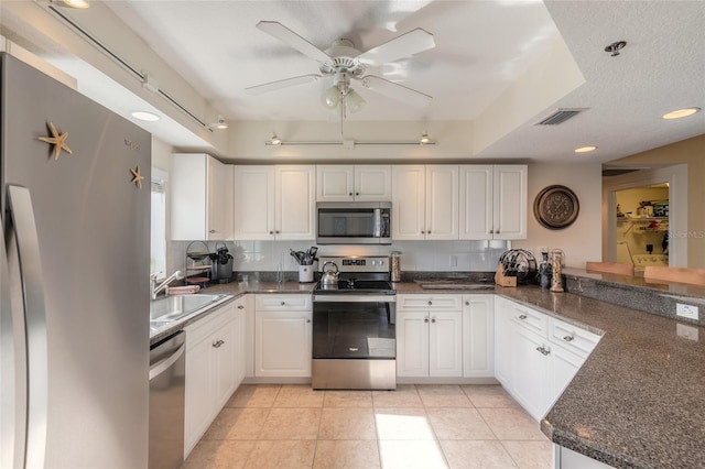 kitchen featuring white cabinetry, light tile patterned floors, kitchen peninsula, and appliances with stainless steel finishes