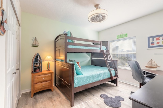 bedroom with light hardwood / wood-style floors and a closet