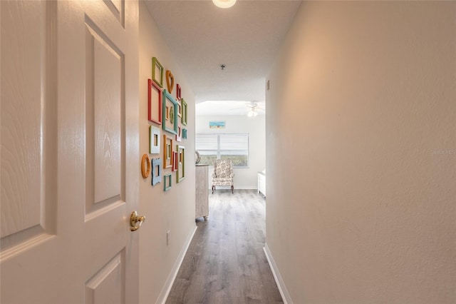 hallway with dark wood-type flooring and a textured ceiling