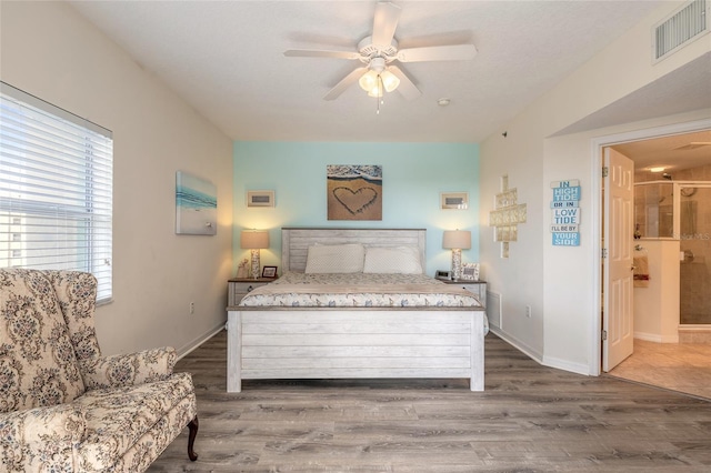 bedroom featuring dark wood-type flooring, connected bathroom, and ceiling fan