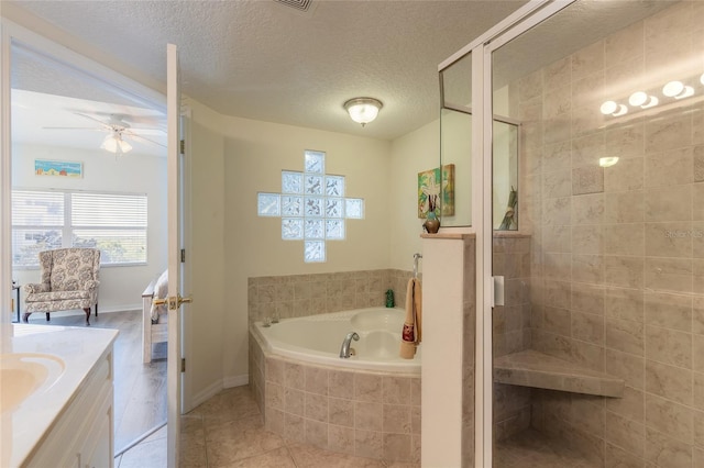 bathroom featuring shower with separate bathtub, tile patterned flooring, vanity, ceiling fan, and a textured ceiling