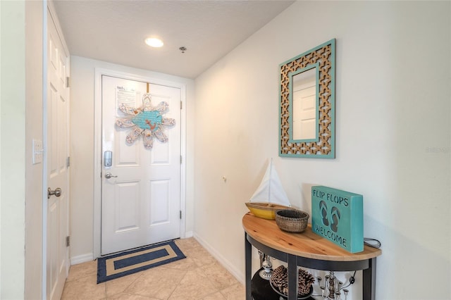 tiled foyer entrance featuring a textured ceiling