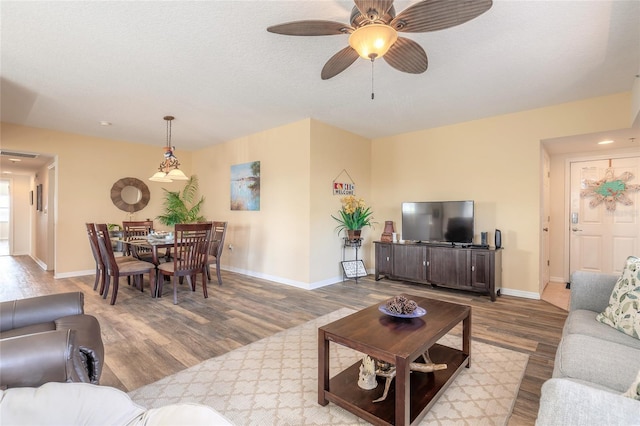 living room with wood-type flooring and ceiling fan