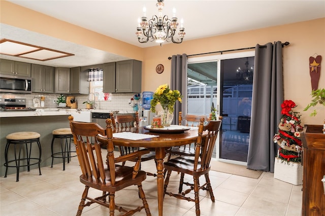 tiled dining area featuring an inviting chandelier, sink, and plenty of natural light